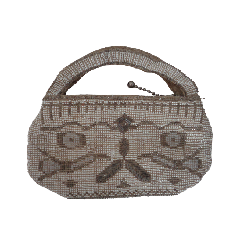 simple white desk on a white wall with a plant on the far right side